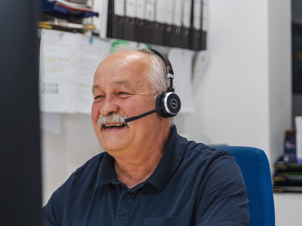 Zoltan Gal mit Headset am Schreibtisch im Büro in Nürnberg
